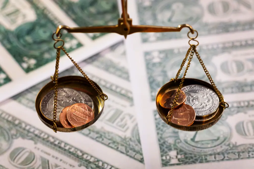 Balança com moedas representando comparação entre juros abusivos e juros legais no sistema financeiro e equilíbrio de cobranças financeiras