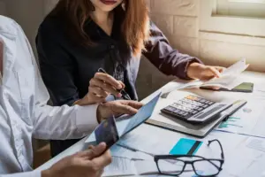 Pessoa analisando contas e calculando despesas com apoio de assessoria financeira para entender dívidas e organizar a situação financeira